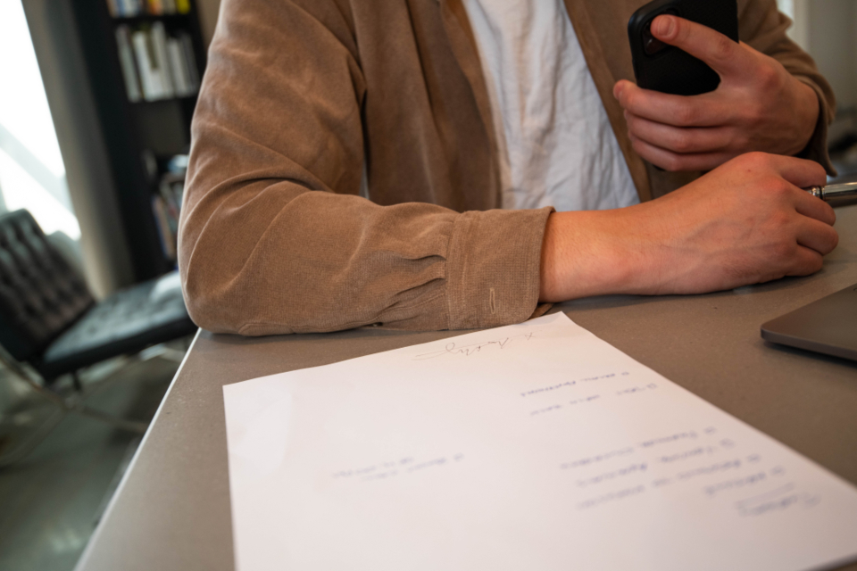 A client signing paperwork at a desk in an office
